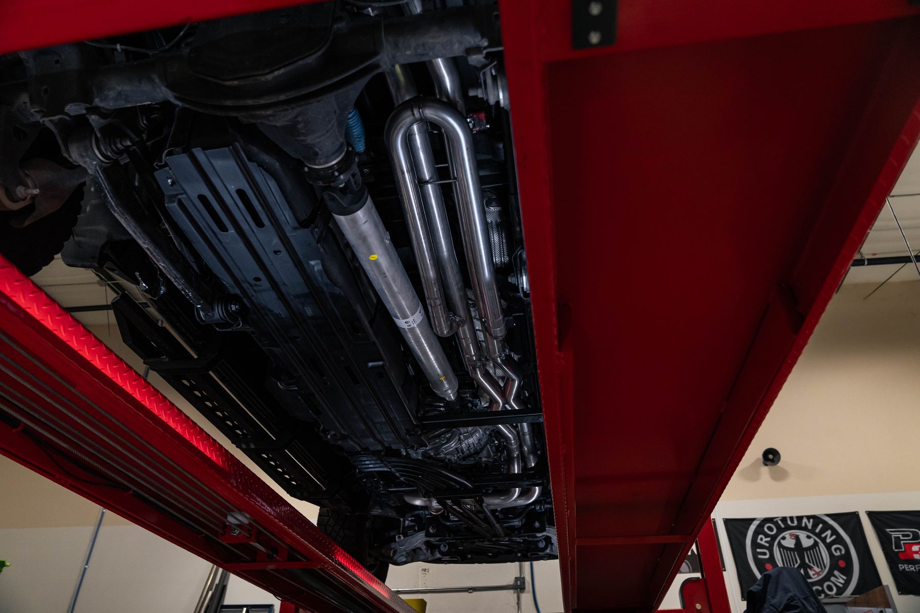Milltek T304L stainless cat-back exhaust installed under the Ram 1500 RHO, viewed from below on a lift