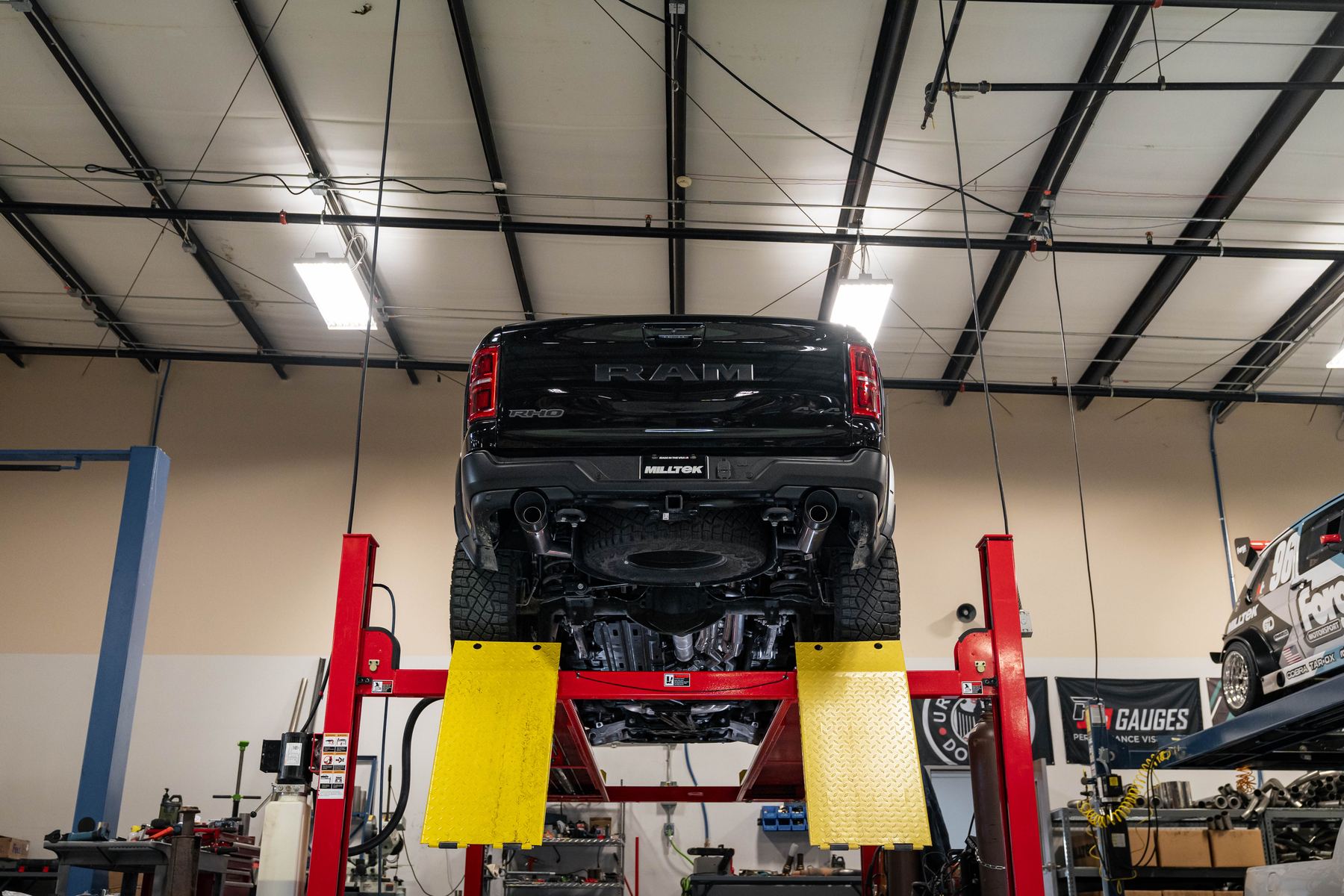 Ram 1500 RHO on a lift in the Milltek Corp workshop during Milltek cat-back exhaust fitment