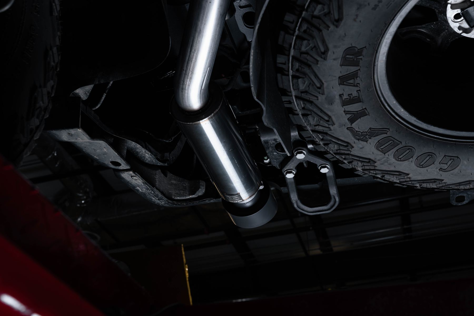 Milltek outlet section of the Ram 1500 RHO cat-back exhaust beside the spare tire